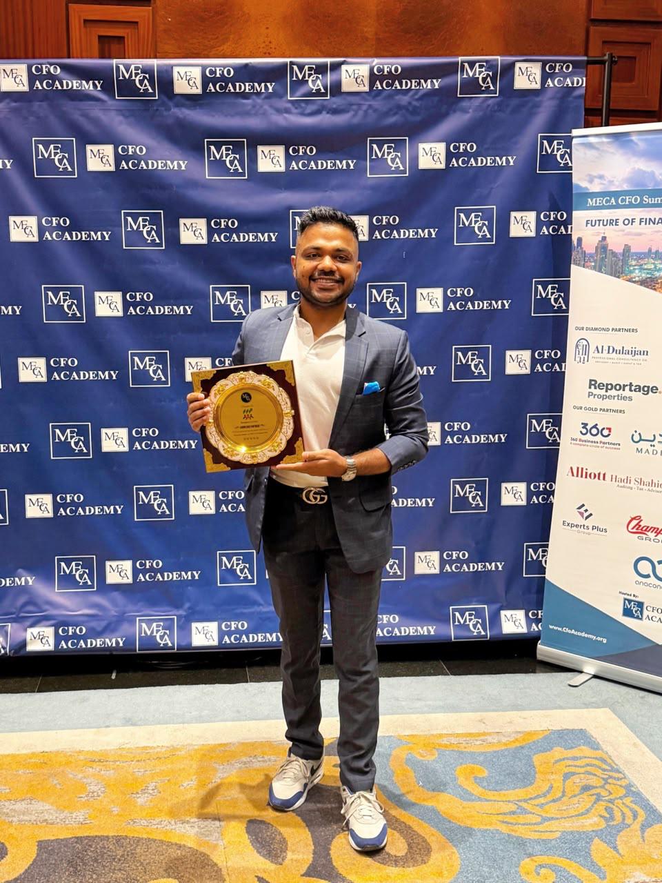 Ekansh Agrawal holding an award at the MECA CFO Academy Summit